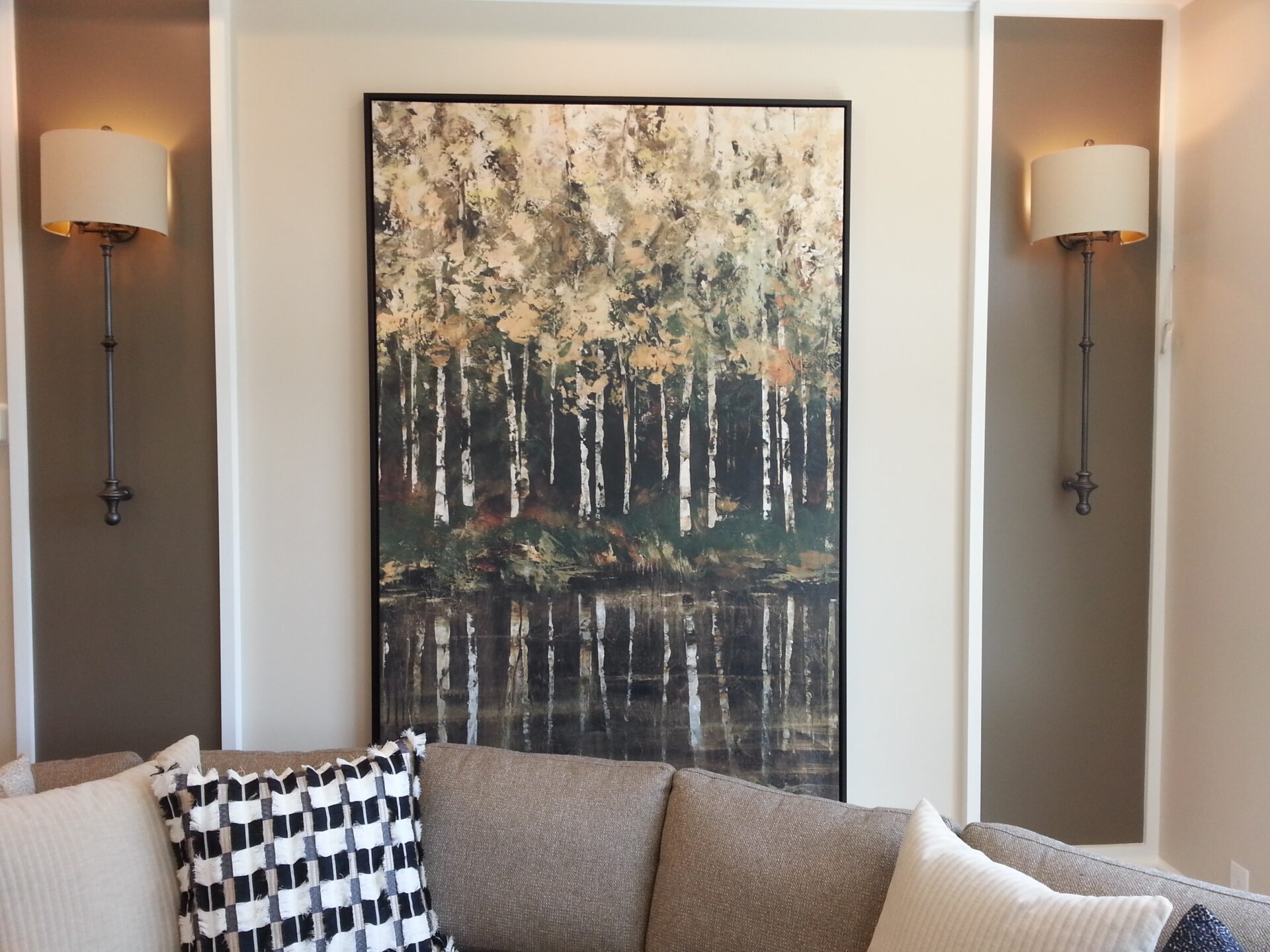A large painting of trees in the middle of a living room.