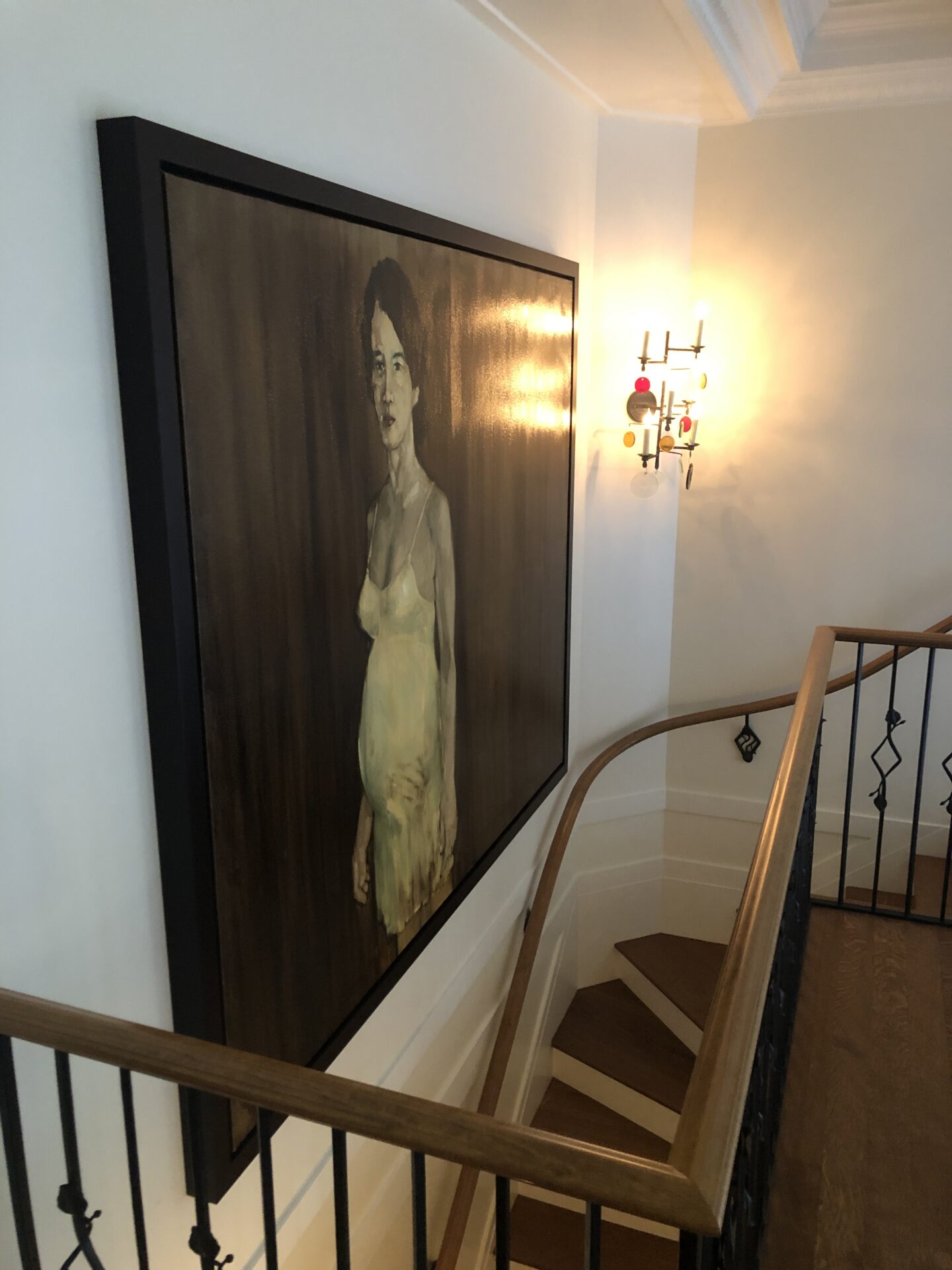 A staircase with a large painting on the wall.